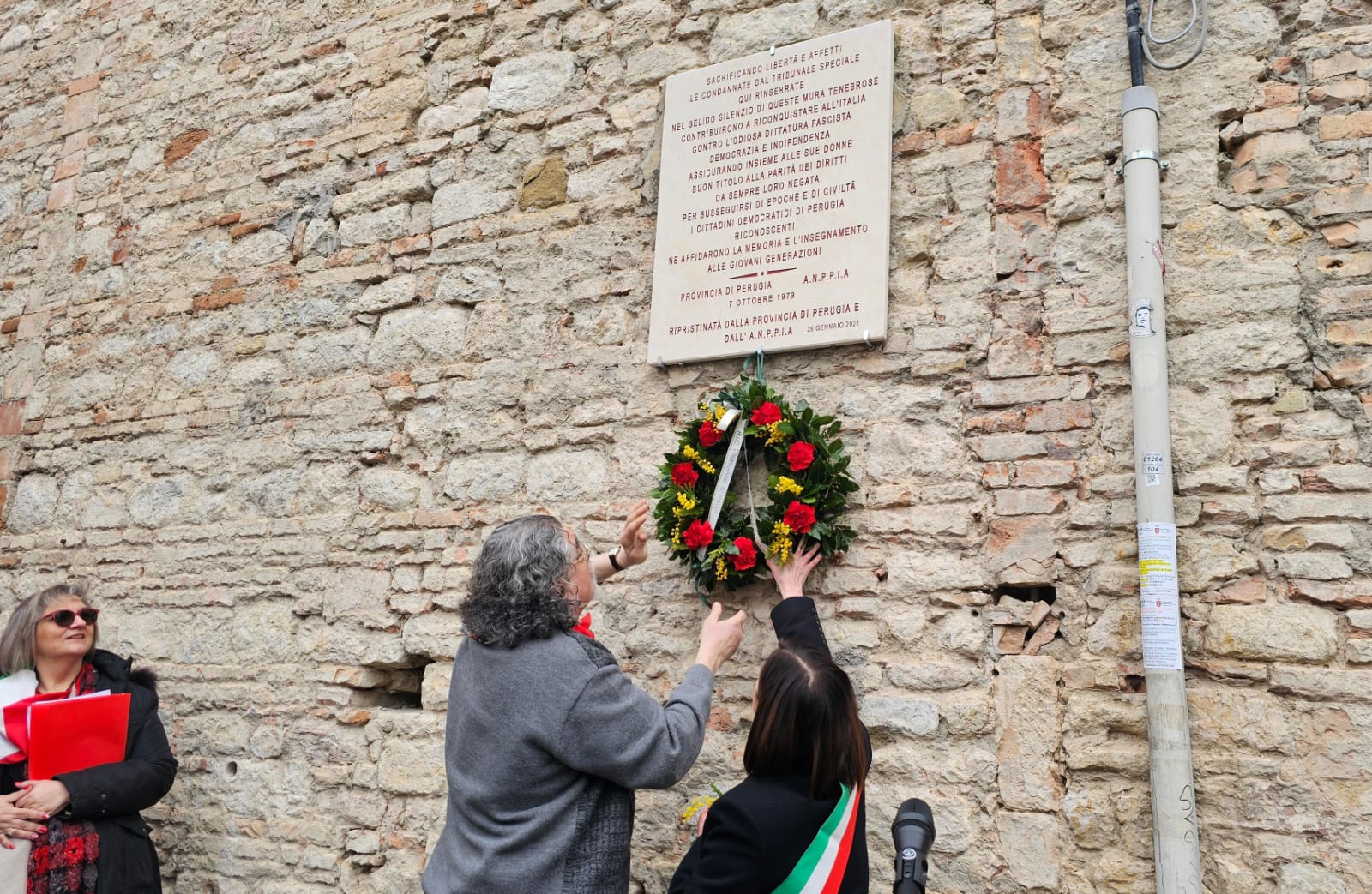 foto del posizionamento della corona di fiori sotto la lapide commemorativa